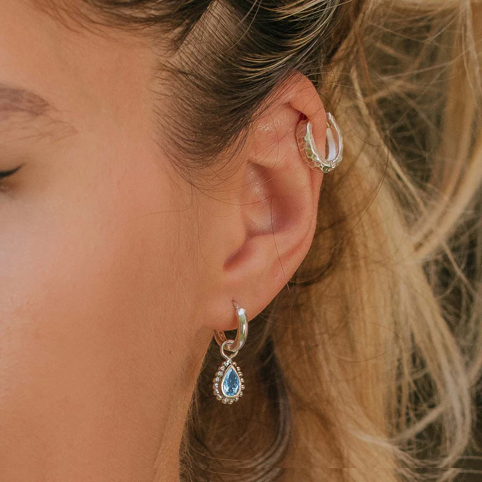 Woman wears both helix and drop earrings